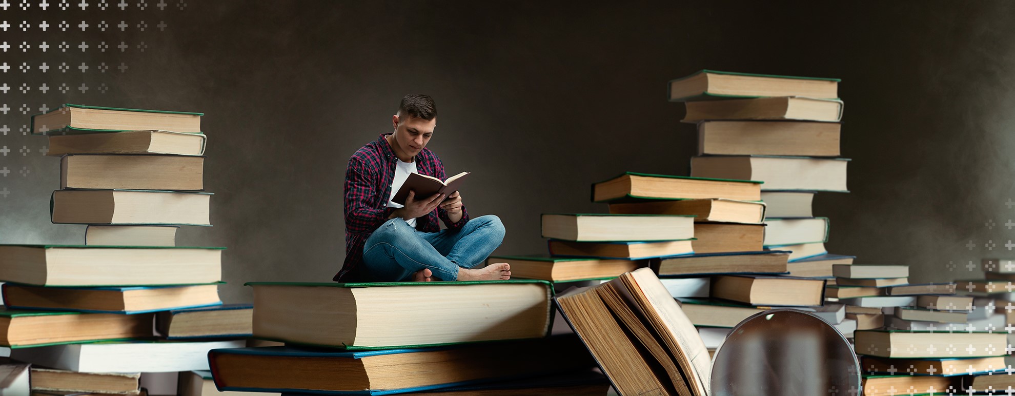 tipos de textos - imagem de um homem sentado sobre um livro, enquanto lê um livro